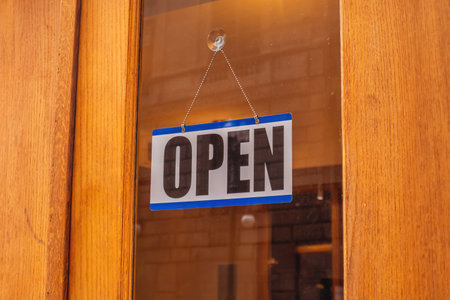 Open text sign on a glass entrance door, close up