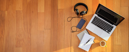 Home office, Work from home. Computer laptop, mobile phone, headphones on the wooden floor, top viewの写真素材