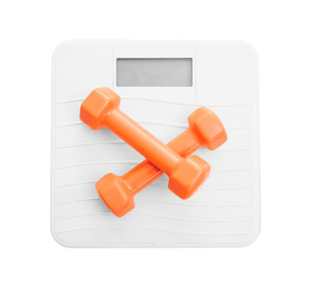 Dumbbells on a bathroom scale isolated on white background, top view,