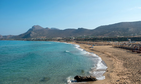 Falasarna sandy beach at Crete island Greece. Umbrella, seaside sunbed, summer vacation, nature, wavy sea, blue sky, sunny day.の写真素材