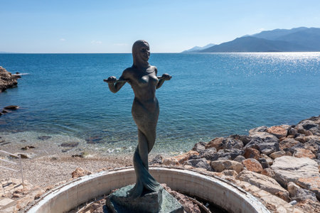 Marmaid Statue at Paralio Astros beach, Peloponnese, Greece. Aerial drone view of Gorgona Stheno, sparkle sea water, blue sky background.の写真素材