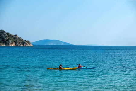 Two canoe kayak with oar in vast blue calm sea. Relaxation with rowing in Greek ocean water. Summer holiday fun and healthy sport activityの写真素材