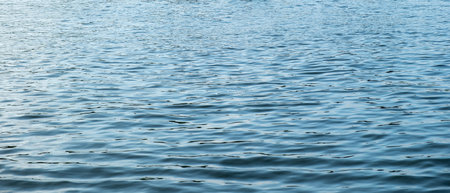 Rippled empty sea background texture. Wavy with reflection light blue ocean water surface. Marine...