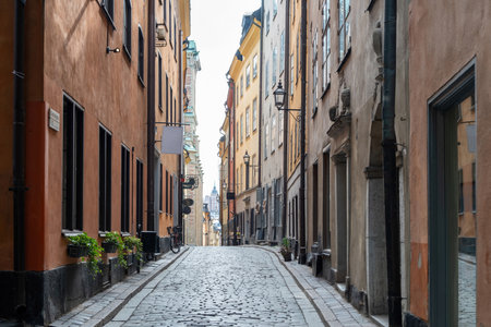 Stockholm Sweden, traditional colorful building with lantern, potted plant, narrow winding cobblestone alley, destination Gamla Stan Old Town.の写真素材