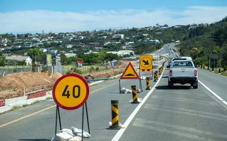 Roadworks at the highway. Warning road signs on the asphalt. Speed limit, traffic cones and...