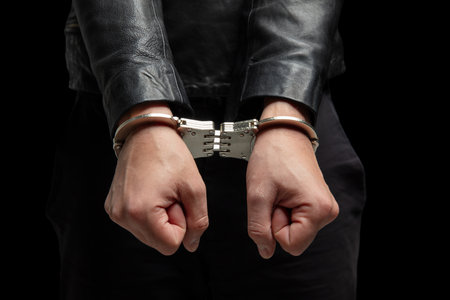 Hands in handcuffs closeup view. Crime, arrest and jail concept