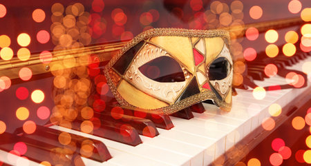 Carnival party music. Venetian female mask on a piano keyboard, masquerade, mardi gras celebrationの写真素材