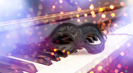 Carnival party music. Venetian female mask on a piano keyboard, masquerade, mardi gras celebrationの写真素材