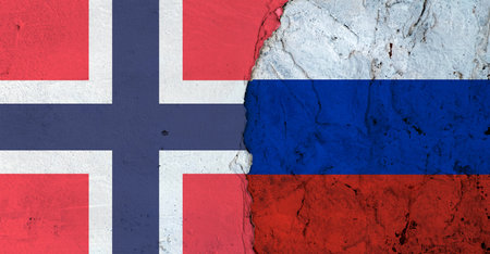 Norway and Russia conflict. Norwegian and Russian country flags on broken wall background.の写真素材