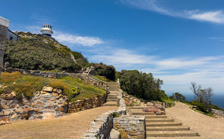 Cape Point lighthouse on the Cape of Good Hope cliffs, Stairs going up to the South Africa landmark, blue cloudy skyの写真素材