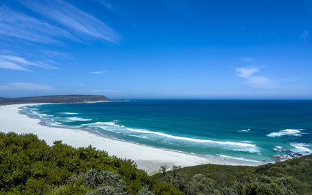 Noordhoek beach near Cape Town, South Africa.  Ocean waves roll in white sand Beach, clear blue skyの写真素材
