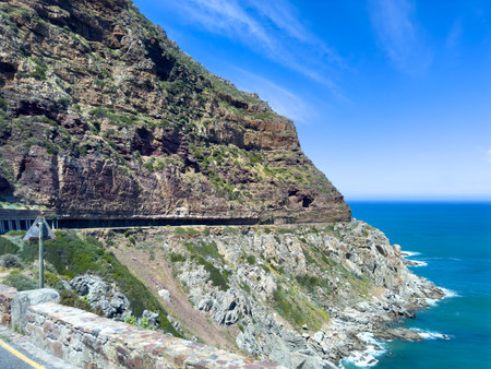 Chapman's Peak Drive, South Africa. Coastal road carved into the mountain cliff, sunny day, blue skyの写真素材