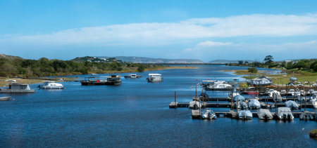 Knysna lagoon marina South Africa. Boats anchored on calm water, blue sky with cloudsの写真素材