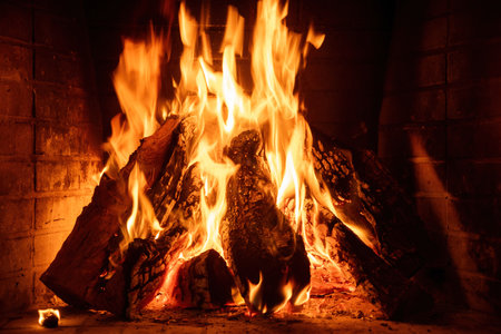 Fire burning in a fireplace, wood logs and flames. Warm home, heat. Christmas holidayの写真素材