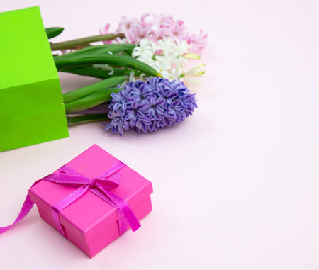 Mothers day gift. Fresh Hyacinths, Spring  flowers and a gift box on pink backgroundの写真素材