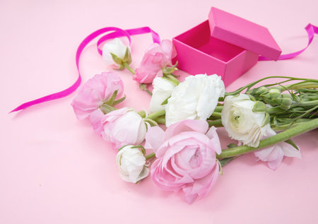 Mother day gift. Pastel color fresh bouquet and an open gift box on pink. Spring, women dayの写真素材