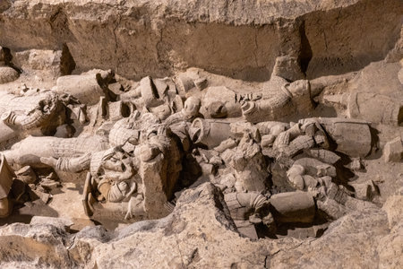 Terracotta Army Warriors archaeological site. Xian, China. Trench filled with broken statues and fragments partially buried in soilの写真素材