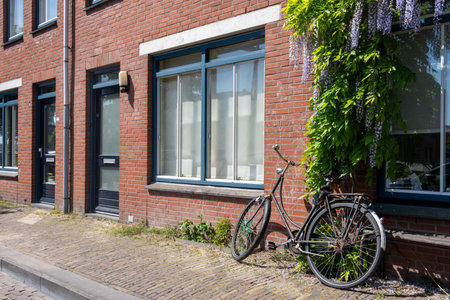 Bicycle parked on sidewalk in front of brickwall building in Delfshaven. Biking in Netherlands Hollandの写真素材