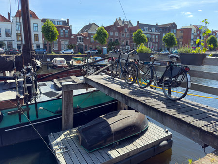 Delfshaven Netherlands Holland. Bike parked over the river water, city waterfront buildings and boats background.の写真素材