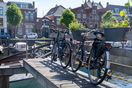 Delfshaven Netherlands Holland. Bike parked over the river water, city waterfront buildings and boats background.の写真素材