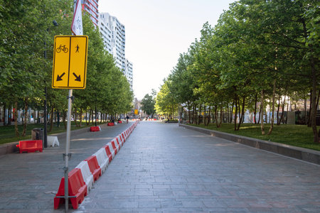 Traffic lanes temporary separation with red and white plastic barriers. Yellow sign arrows for bicycles and pedestrians.の写真素材
