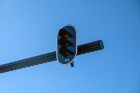 Red traffic light for cars, blue sky background, sunny day.の写真素材