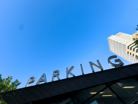 PARKING word sign on the roof. Metallic letters text at the building entrance, blue sky backgroundの写真素材