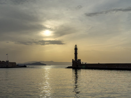 Crete, Chania old harbour. Lighthouse and Firkas Fortress at sunset, rippled sea, cloudy skyの写真素材