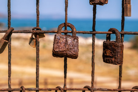 Love lock. Rusty padlocks on metal fence grid, closeup view. Love and commitment concept
