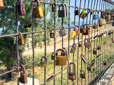 Love lock. Rusty padlocks on metal fence grid, closeup view. Love and commitment conceptの写真素材