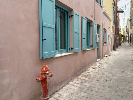 Chania old town architecture. Crete island, Greece. Blue wooden shutters on a pink wall, narrow cobblestone alleyの写真素材