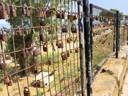 Love lock. Rusty padlocks on metal fence grid, closeup view. Love and commitment concept