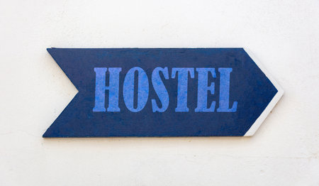 HOSTEL text sign arrow, blue wooden direction sign isolated on whiteの写真素材
