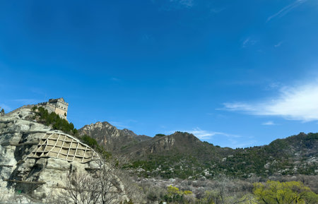 China. Great Wall, Stone watchtower and sections of the Wall on rocky mountain landscape, blue sky, sunny dayの写真素材