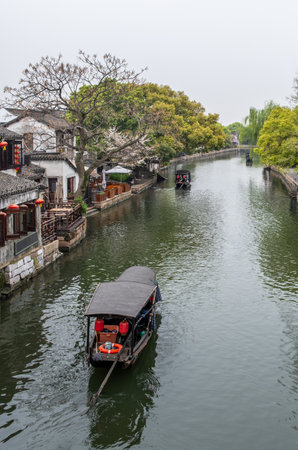 China water town Xitang. Boat on water, traditional chinese architecture buildings on river banksの写真素材