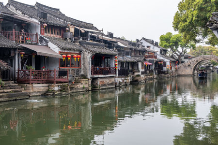 China water town Xitang. Boat on water, traditional chinese architecture buildings on river banksの写真素材