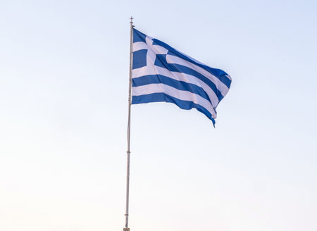 Greek national flag. Greece sign symbol on flagpole waving in the wind, blue skyの写真素材