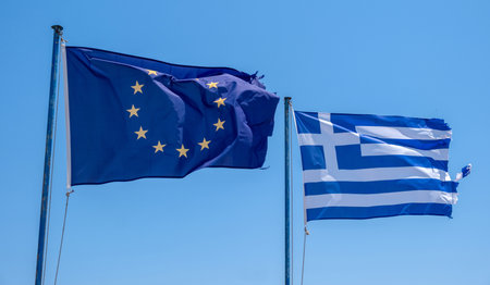 Greek national flag. Greece sign symbol on flagpole waving in the wind, blue sky, sunny dayの写真素材