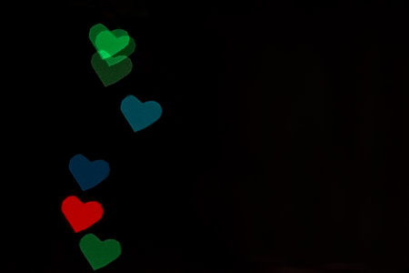 Multicolored heart-shaped lights on the black background
