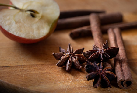 Apple pie ingridients. Cooking at home. Apple cut in half, cinnamon sticks and anise stars on wooden chopping boardの写真素材