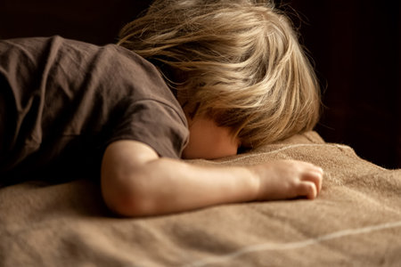 child is lying on the bed face down