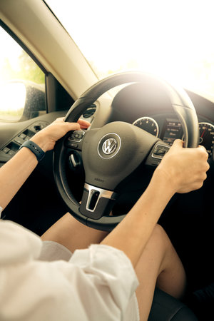 August 2022, Moscow Russia - woman drives VW Volkswagen car, inside view, hands holding steering wheel close upのeditorial素材