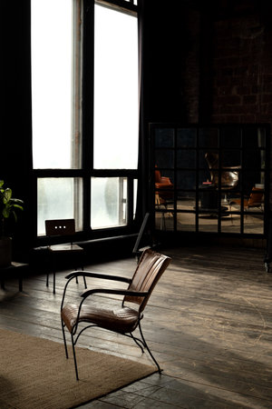 leather upholstered retro styled chair stands in empty room bathed in sunlight