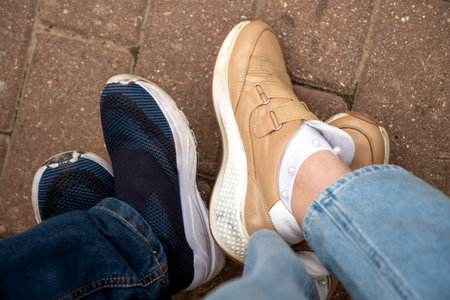 Look down on couple of human legs wearing casual boots or shoesの写真素材