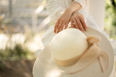 Close up  straw hat holded by young woman in her hand, summer outdoor lifestyle outfitの写真素材