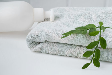 Cosmetic dispenser lays on fresh towel on bathroom toptableの写真素材