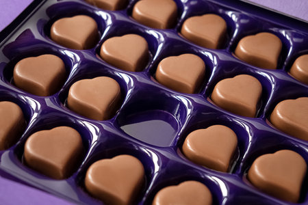 Opened box of heart-shaped chocolates with one empty cell. Valentine's Day celebrationの写真素材