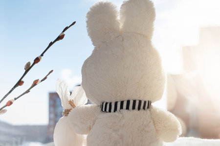 Fluffy easter bunny with decorated egg on sunlight background. Waiting for spring concept, selective. focusの写真素材
