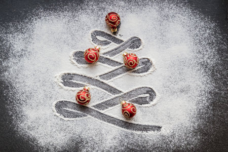 View from above on Christmas tree painted on floured background decorated with small red ballsの写真素材