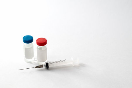 two vials of vaccine and syringe for injection on light backgroundの写真素材